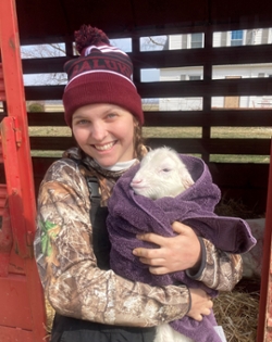 Carly Etter, an Honors student holding a baby goat