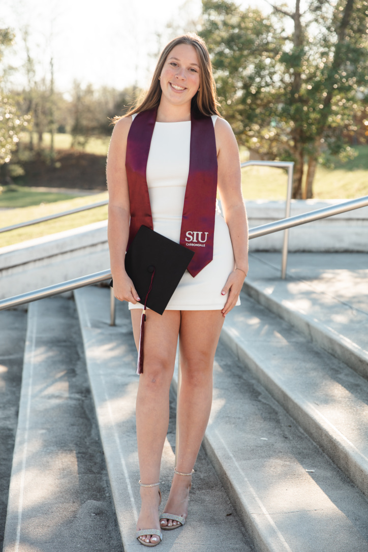 Elizabeth Williams holding her grad cap and siu stole for graduation