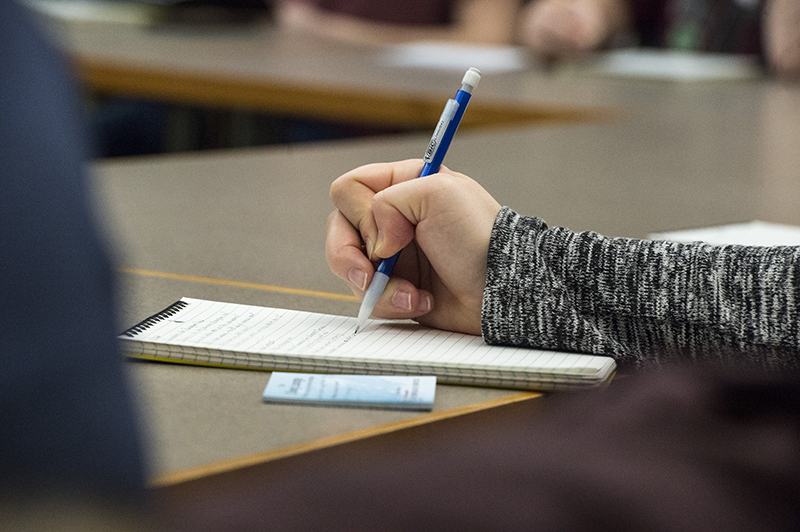 Closeup of Honors student taking notes during class